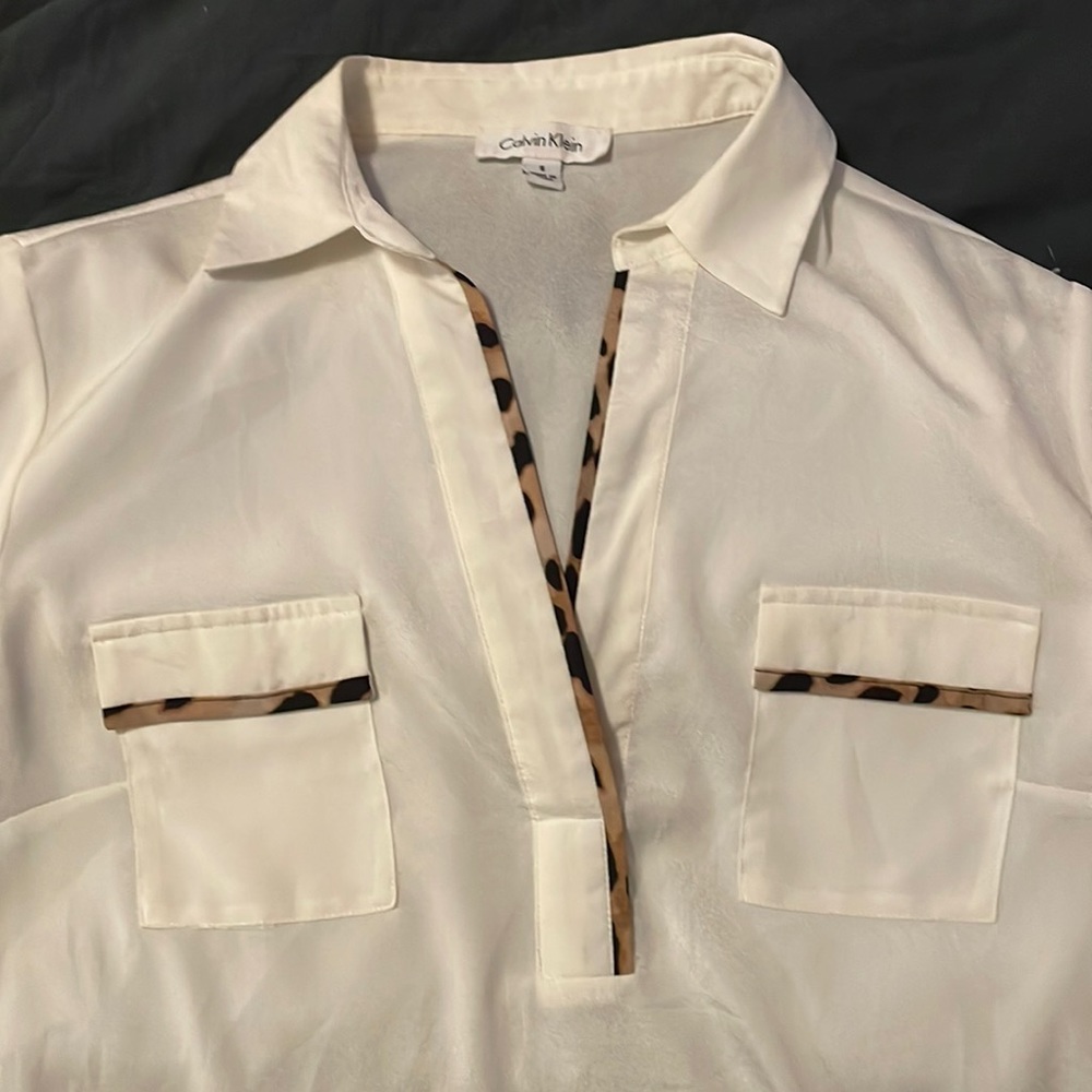 And Klein pull over cream blouse with leopard accents. Size small